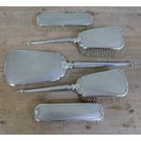 A five piece silver dressing table set comprising a hand mirror and four brushes, Charles S