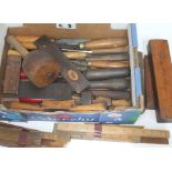 A box of vintage wooden hand tools including rulers, mallet, chisels, scribers, whetstones etc