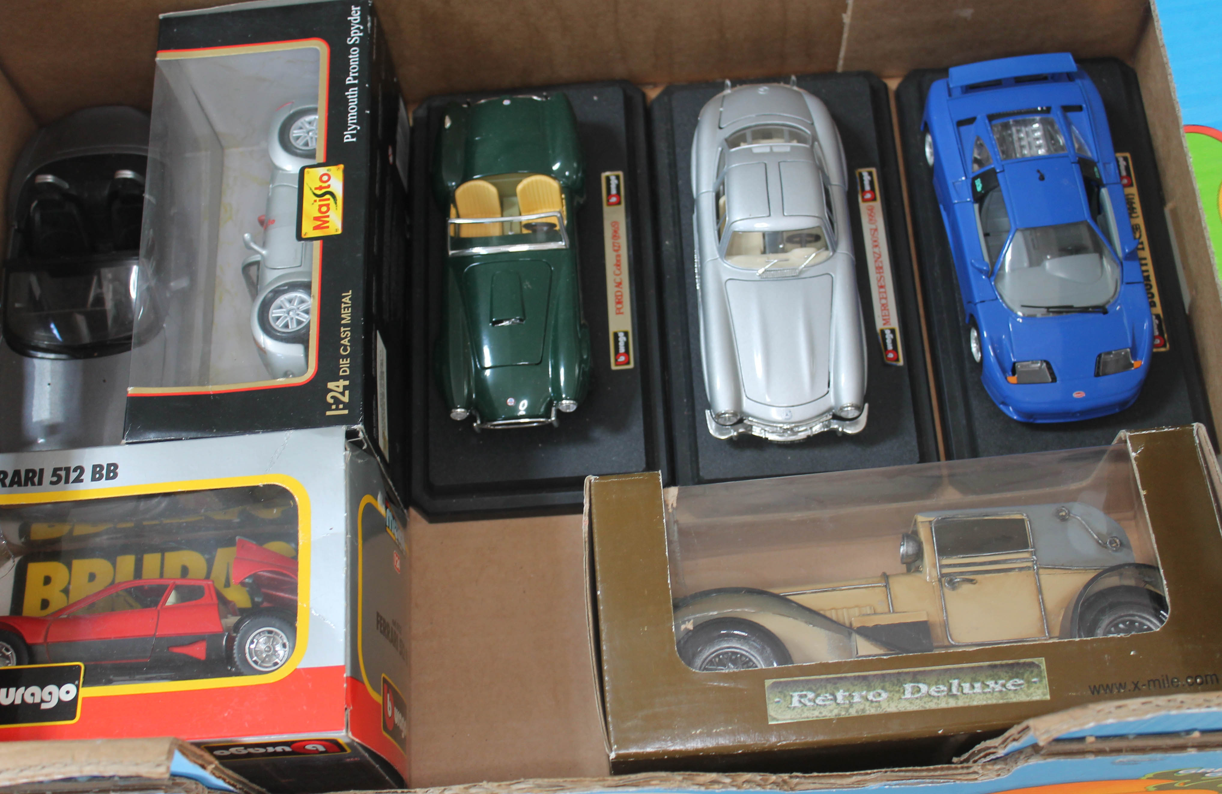 A box of 7 model cars in cluding Maisto and Burago. Vehicles include Plymouth Pronto Spyder, Ferrari