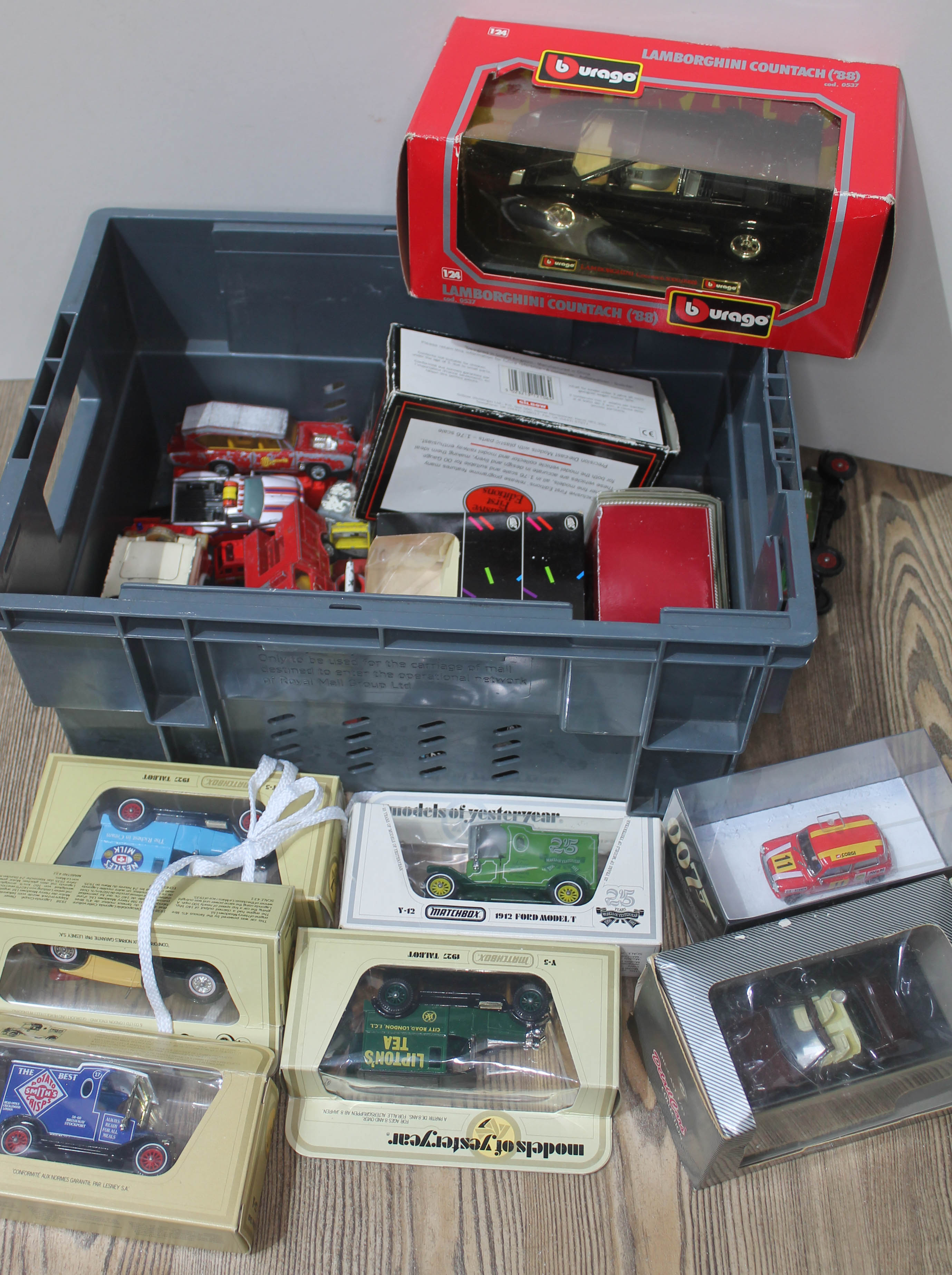 A crate of boxed model cars including Burago