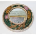 A round plaster wall mirror, moulded with tulip decoration, diam. 38cm.