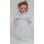 An Armand Marseille doll, number 990, on stand, height approx. 48cm.