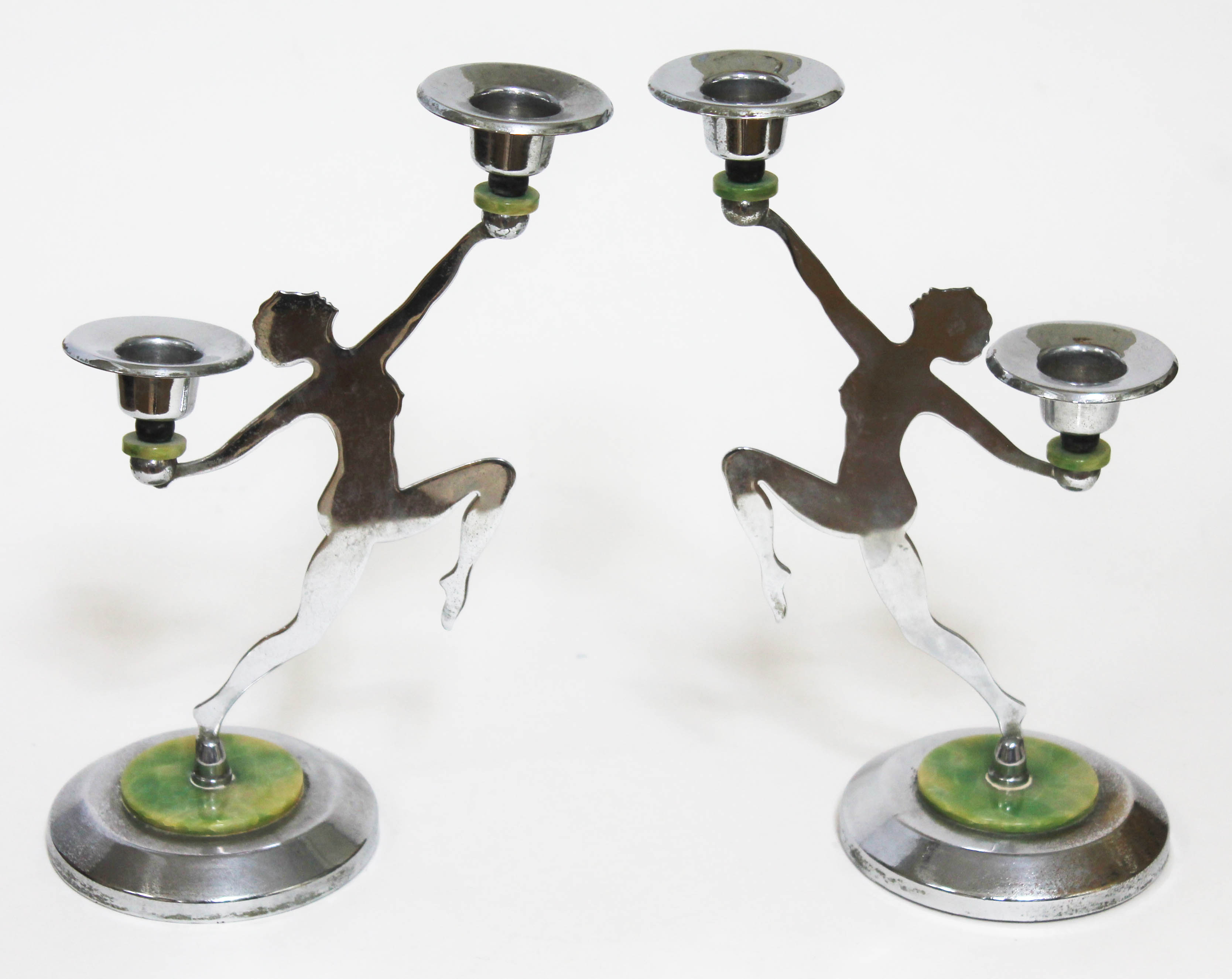 A pair of Art Deco chrome candelabra formed as nude dancing girls in side profile and holding a