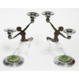 A pair of Art Deco chrome candelabra formed as nude dancing girls in side profile and holding a