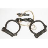 A pair of antique handcuffs with key numbered 132.