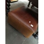 A brown leather pouffe