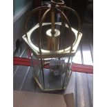 A hexagonal brass and glass light fitting.