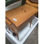 A retro sewing box on tapered legs