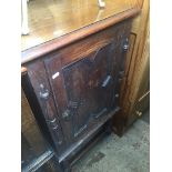 An oak music cabinet with geometric door panel