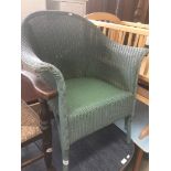 A green woven Lloyd Loom tub chair