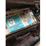 A vintage suitcase containing sewing patterns etc