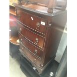 A reproduction small bow front chest of drawers