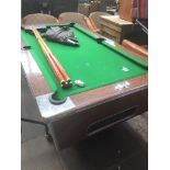 A pool table, cues, balls and cover