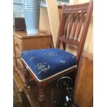 An upholstered oak chair with brass front castors