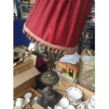 A brass table lamp in shape of pitcher with cherub handle + shade on metal plinth. Catalogue only,