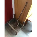 A cast metal fire grate and a large smelting ladel Catalogue only, live bidding available via our