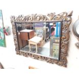 A rectangular wooden ornate framed mirror 90cm x 70cm Catalogue only, live bidding available via our