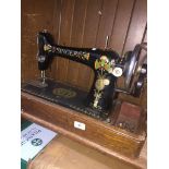 A cased hand cranked Singer sewing machine Catalogue only, live bidding available via our website.