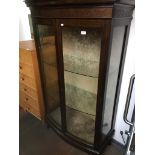 A mahogany bow front glazed display cabinet Catalogue only, live bidding available via our