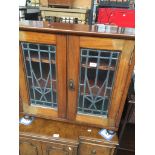 A small cupboard with leaded glass, on castors. Catalogue only, live bidding available via our