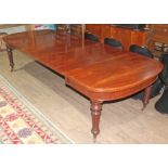 A mahogany wind out table circa 1850, D ends, turned and fluted legs terminating on gilt brass and