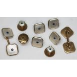 An Art Deco 9ct gold buttong and cufflink set, each set with mother of pearl and a central sapphire,