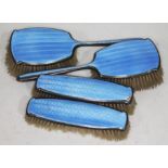 A hallmarked silver and blue enamel dressing table brushes.