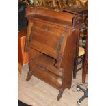 An Arts & Crafts style oak bureau, rail with cut outs and drop down front with straps, in the manner