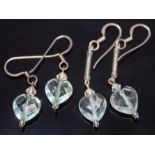 Two pairs of aquamarine earings, each formed as a facetted heart shaped cut stone on drop, lengths