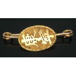 A brooch with Chinese characters, the pin hallmarked 9ct gold, the plaque marked 'KMS20', gross