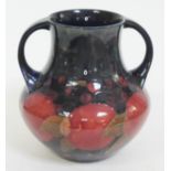 A Moorcroft pottery twin handle vase decorated in pomegranate, height 21cm.