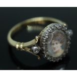 A Georgian portrait ring, depicting a lady surrounded by diamonds, marked '18ct', gross wt. 5.02g,