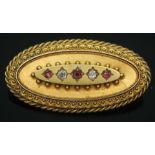 A hallmarked 15ct gold diamond and red stone brooch, gross wt. 9.29g, length 41mm, with case.