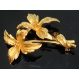 A floral spray brooch, marked '375', length 42mm, wt. 7.96g.