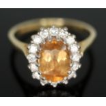 A citrine and diamond cluster ring, the central stone measuring approx. 8mm x 5mm x 2mm, surrouned