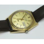 A vintage gold plated Bulova Accuquartz day date wristwatch with gold tone dial