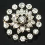 An Art Deco diamond cluster brooch, the old cut central stone weighing approx. 0.25 carats, surround