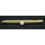 A bar brooch set with a cultured pearl, marked '750', length 52mm, gross wt. 4.42g.
