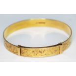 A hallmarked 18ct gold bright cut engraved and adjustable bangle, wt. 30.93g.