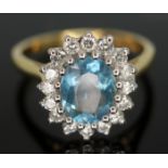 An aquamarine and diamond cluster ring, the oval brilliant cut central stone measuring approx. 8cm x