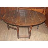 An 18th century joined oak gate leg table, together with eight ladder back and rush seated chairs.