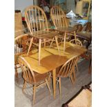 An Ercol blonde drop leaf table and six chairs.