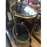 A brass and glass two tier cake trolley Catalogue only, live bidding available via our website.