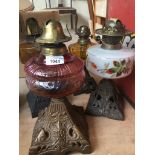 A group of five Victorian oil lamps with cast metal bases and glass reservoirs, heights 29cm - 33cm.