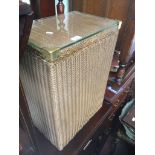 A gold Lloyd Loom style linen basket with glass top Catalogue only, live bidding available via our