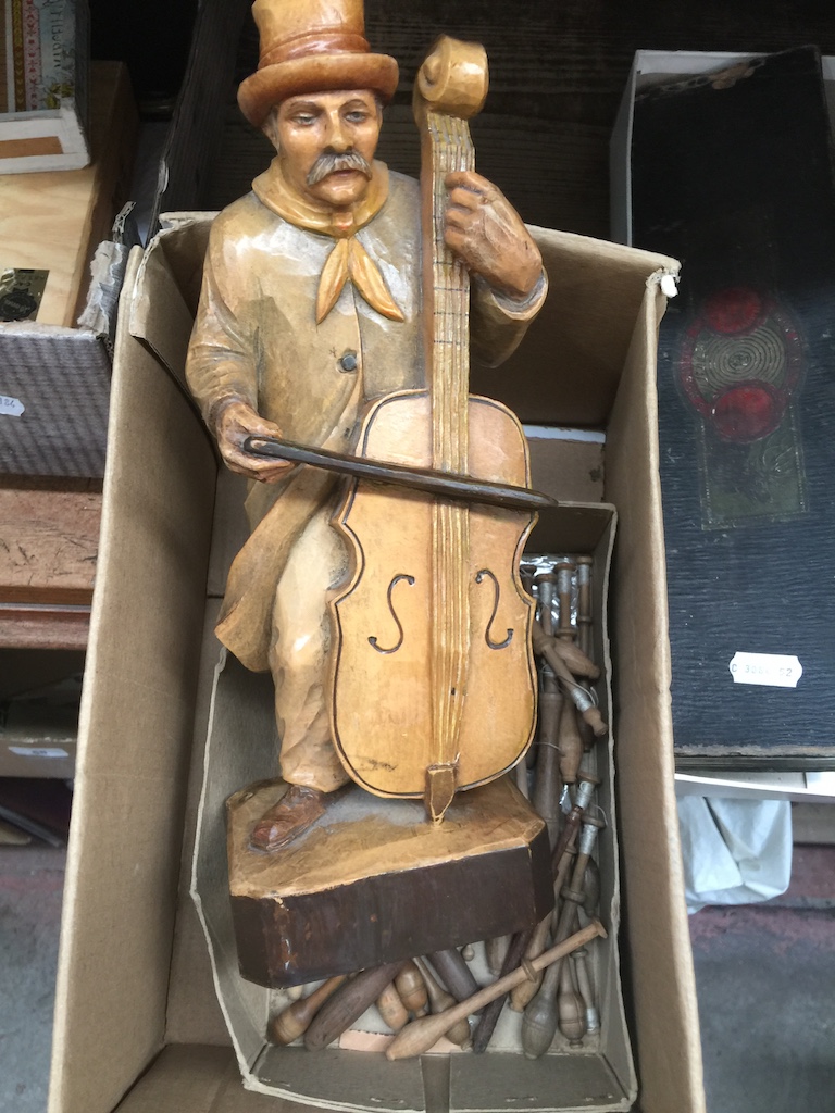 A vintage treen Black Forest cello player and a box of wooden lace bobbins Catalogue only, live