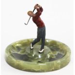 An early 20th century onyx ash tray with mounted cold painted golfer, height 13cm, from the estate