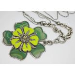 A contemporary flower pendant with green dyed agate petals, yellow enamel and set with paste,