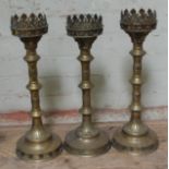 A group of three church brass candlesticks, height 47cm - 49cm.