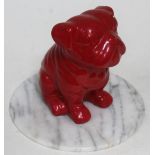 A red bulldog on alabaster plinth.